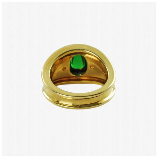 Gold ring with a green gemstone on a white background