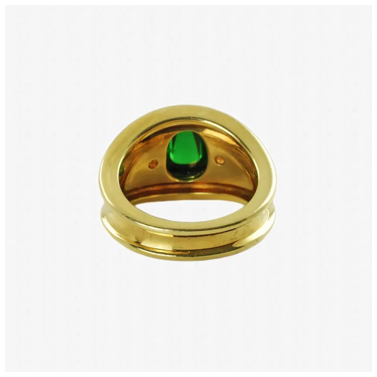 Gold ring with a green gemstone on a white background