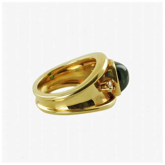 Gold ring with a black gemstone and diamond on a white background