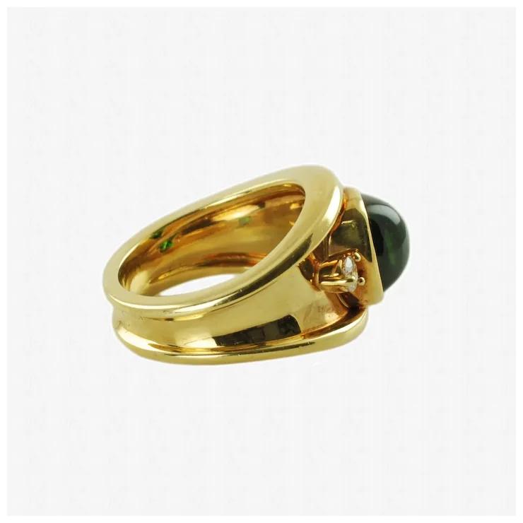 Gold ring with a black gemstone and diamond on a white background
