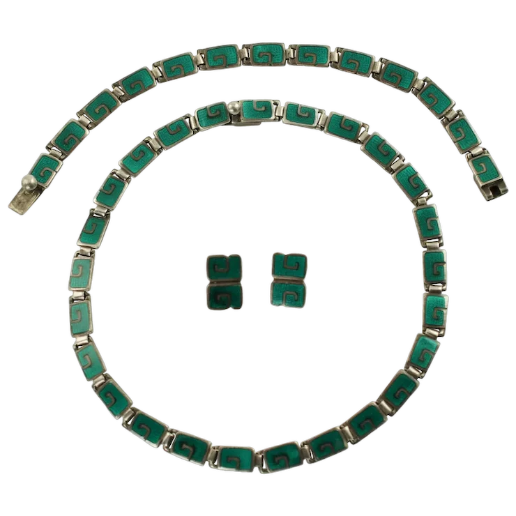 Green and silver jewelry set including a necklace and earrings on a white background
