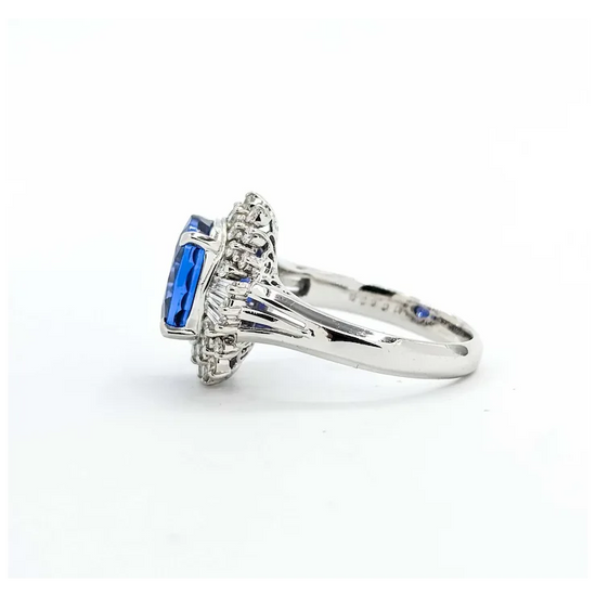 Silver ring with blue gemstone and diamonds on a white background