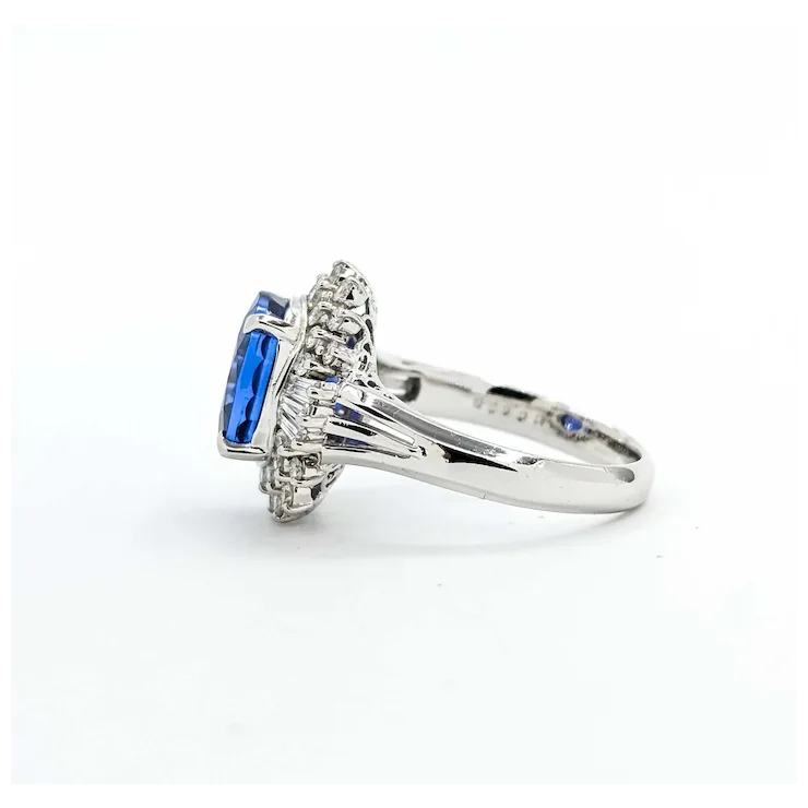 Silver ring with blue gemstone and diamonds on a white background