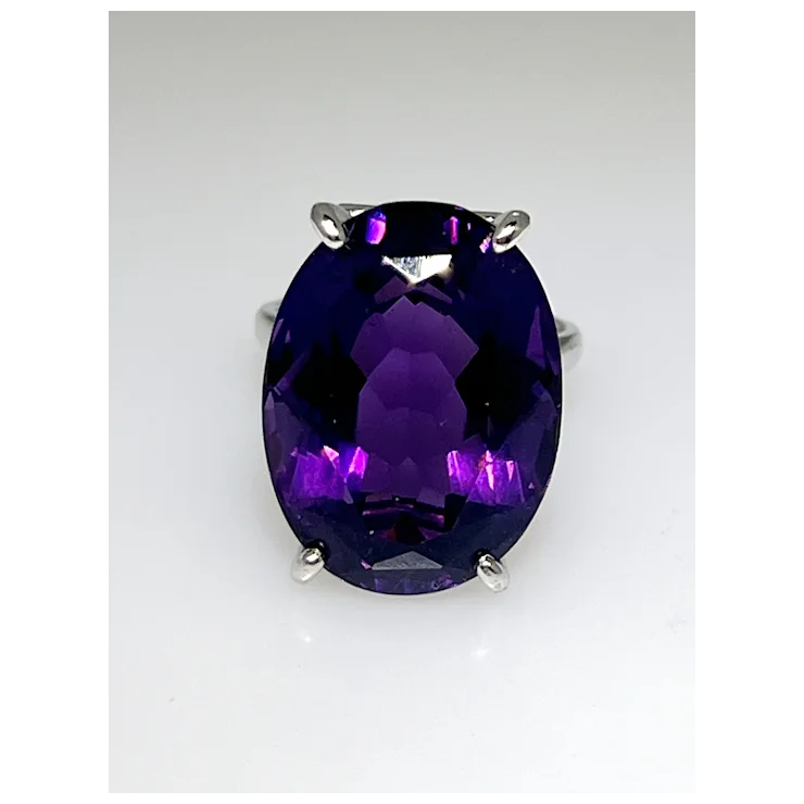 Ring with a large purple gemstone on a white background