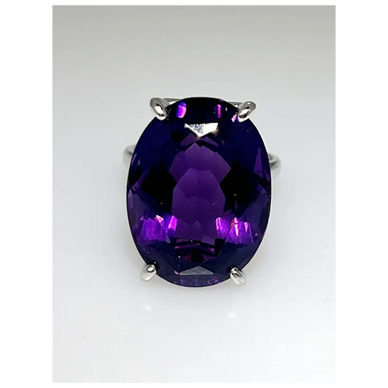 Ring with a large purple gemstone on a white background