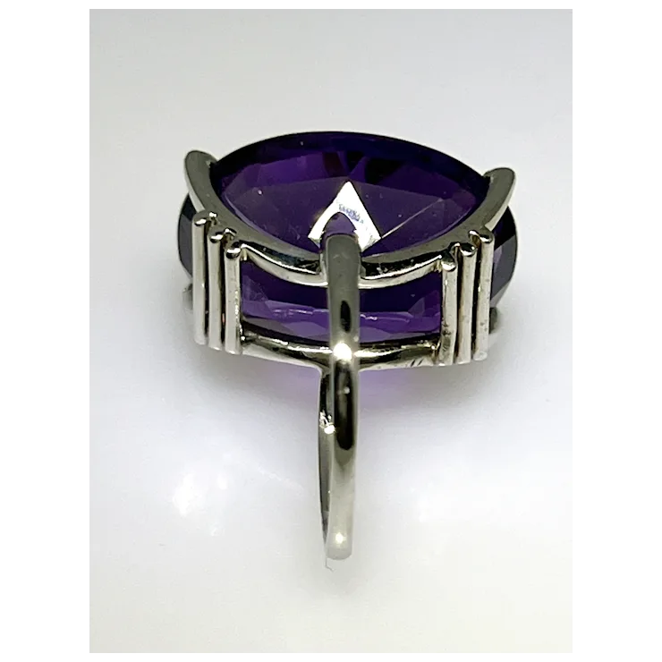 Silver ring with a large purple gemstone on a white background