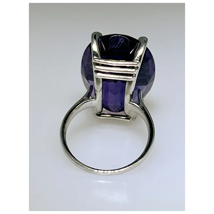 Silver ring with a purple gemstone on a white background